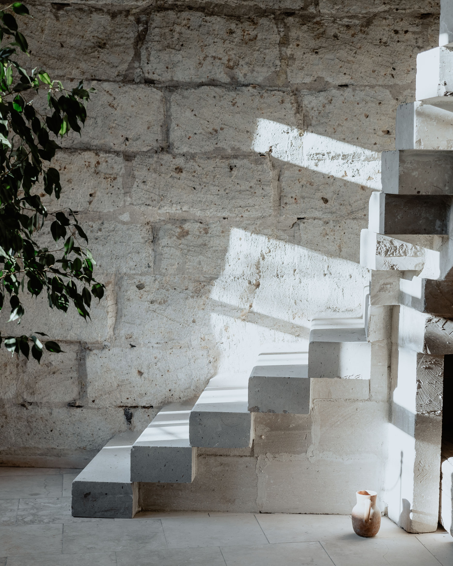 Escalier de pierre baigné de lumière dans un bâtiment ancien